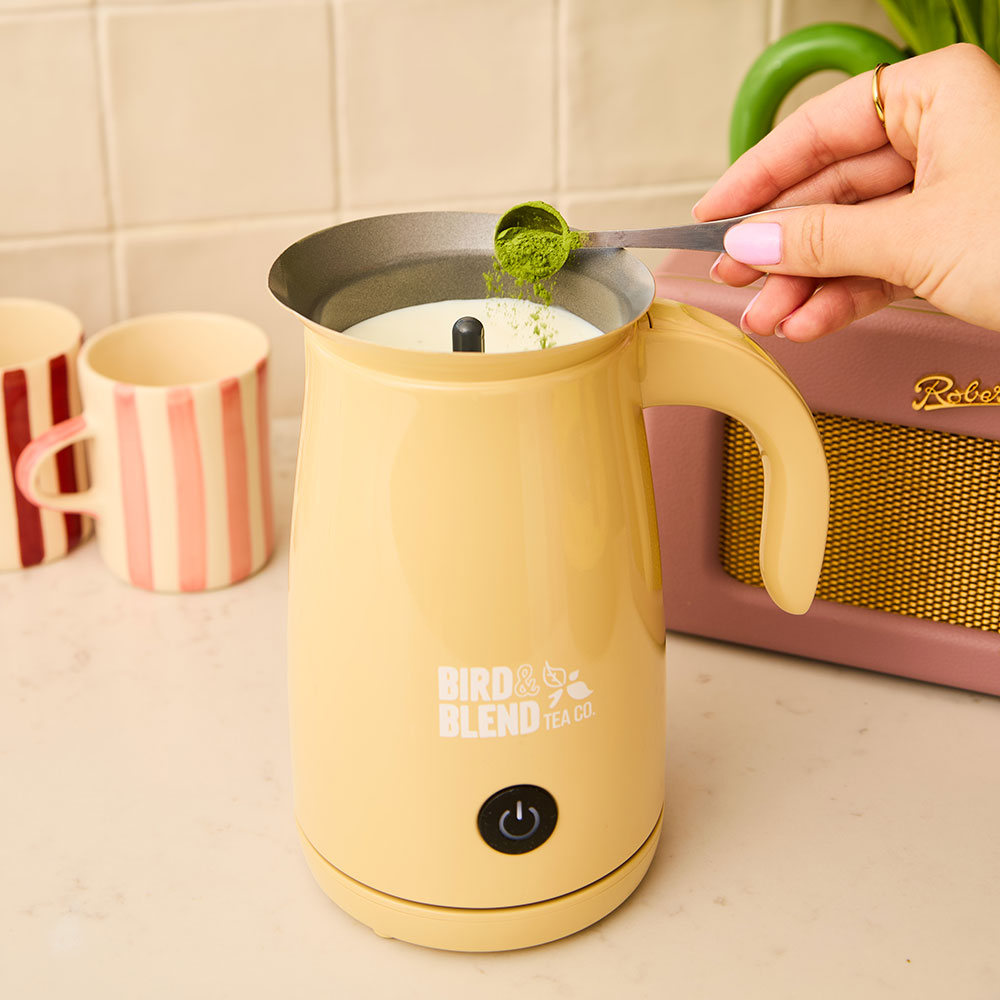 bamboo matcha whisk with matcha being sprinkled in