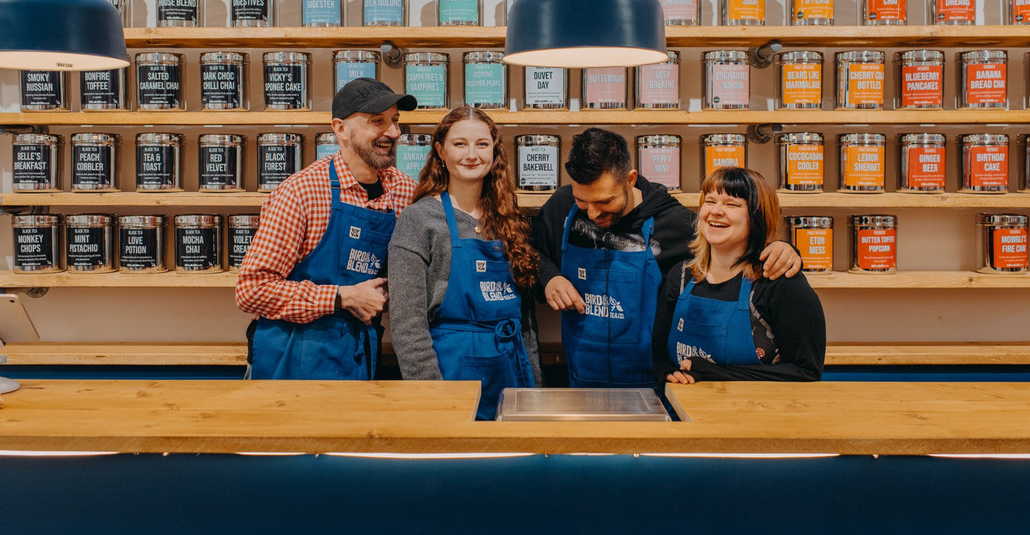 Tea mixologists standing in front of the tea wall
