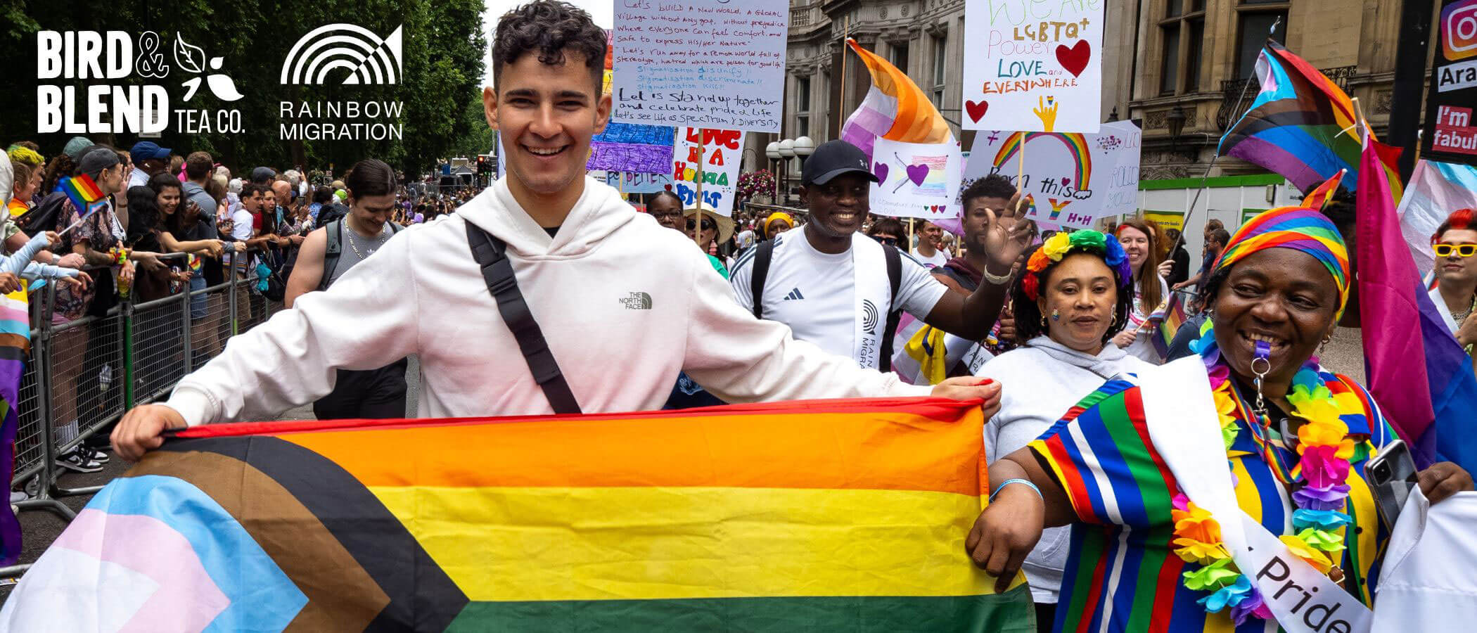 Charity of the quarter rainbow migration marching whilst holding a LGBTQI+ Flag and posters