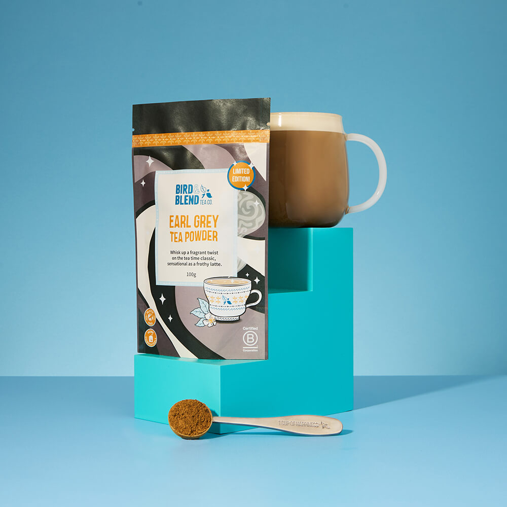 earl grey tea powder pouch and spoon and hot latte blue background