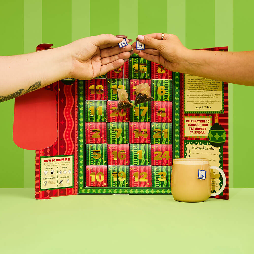  Tea Advent Calendar Open Showcasing All the Numbered Day Cubes Filled With Tea Bags & Two People Holding Up Tea Bags 