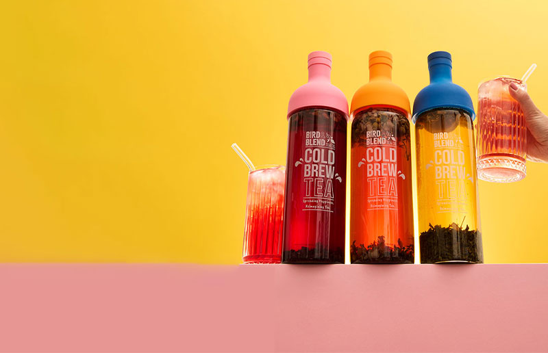  three cold brew tea bottles & hand holding iced tea 